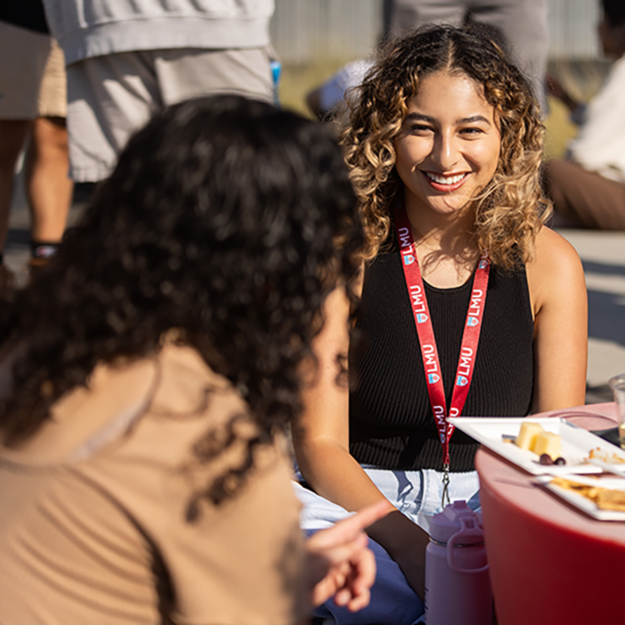 Two LMU Grad students talk at a student mixer